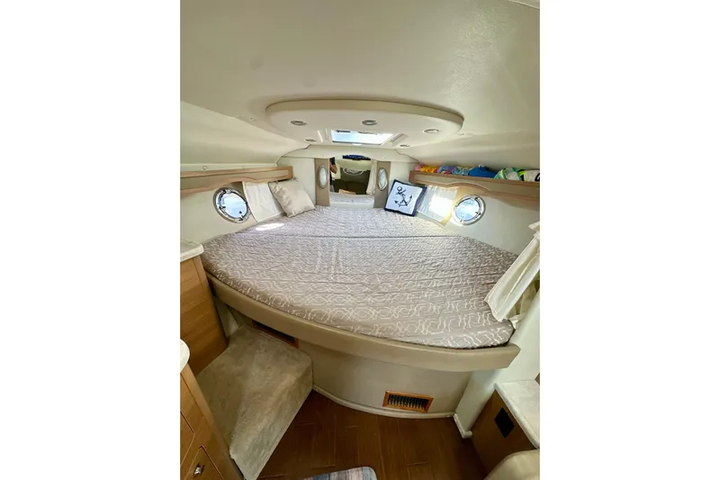 Carpe Diem Yacht Photos Pics 2015 Rinker 340 Express Cruiser cabin with circular bed and porthole windows.