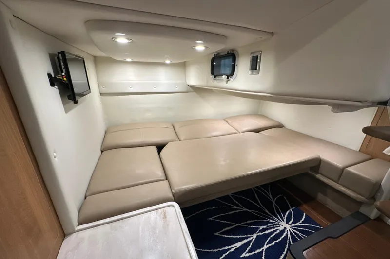 Carpe Diem Yacht Photos Pics 2015 Rinker 340 Express Cruiser cabin interior with beige seating and wall-mounted TV.