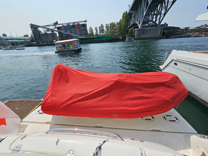 Wrist Shot Yacht Photos Pics 2005 Sea Ray 48 Sundancer with red-covered equipment on deck, near a bridge and waterway.