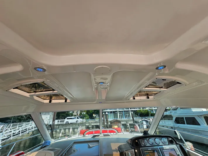 Wrist Shot Yacht Photos Pics Interior view of 2005 Sea Ray 48 Sundancer yacht cockpit with sunroof and control panel.