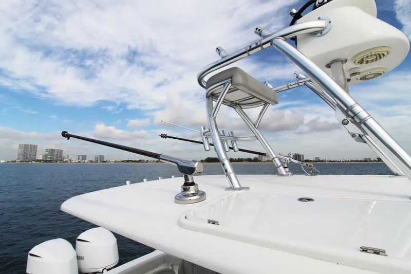  Yacht Photos Pics 2019 Jupiter 30 HFS boat with fishing equipment on a calm sea, city skyline in background.