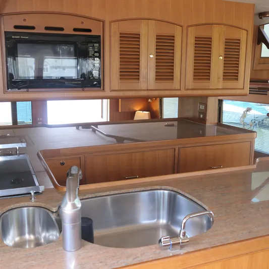  Yacht Photos Pics Interior of 2008 Marlow 53 C Explorer yacht kitchen with wood cabinets and stainless steel sink.