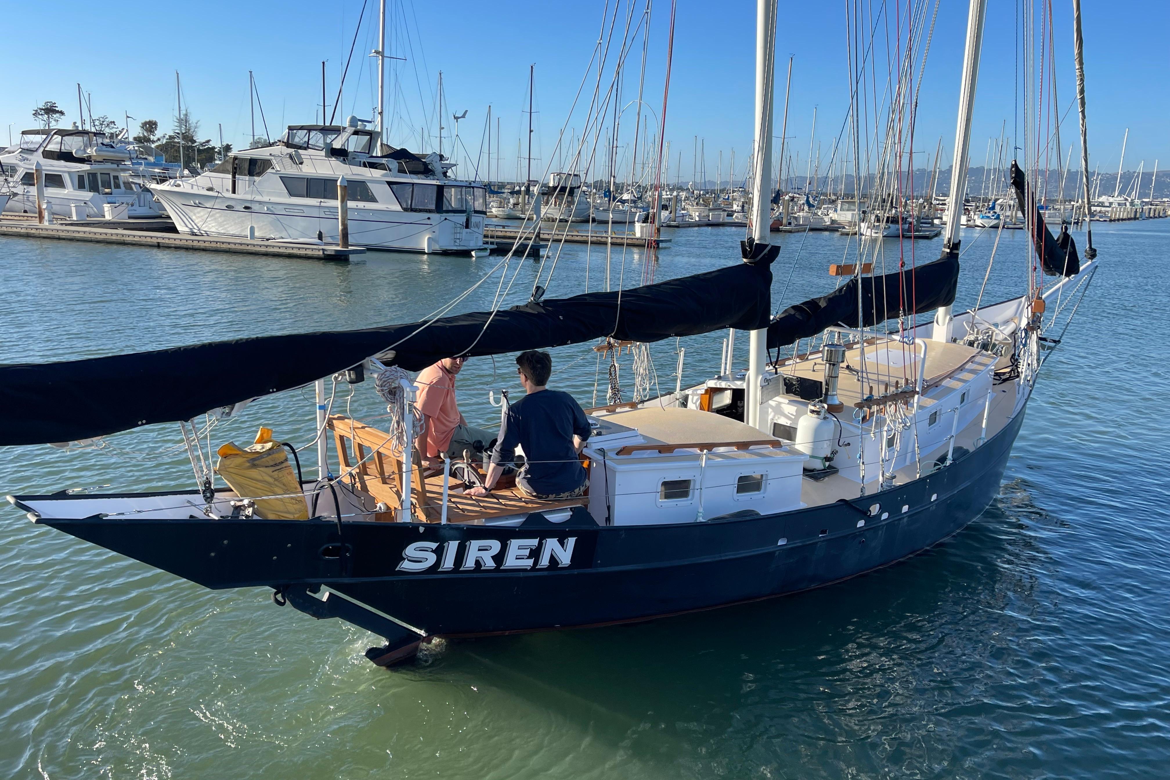 Sailing yacht "Siren" by Pinky Custom, 2008, docked in a marina with two people aboard.
