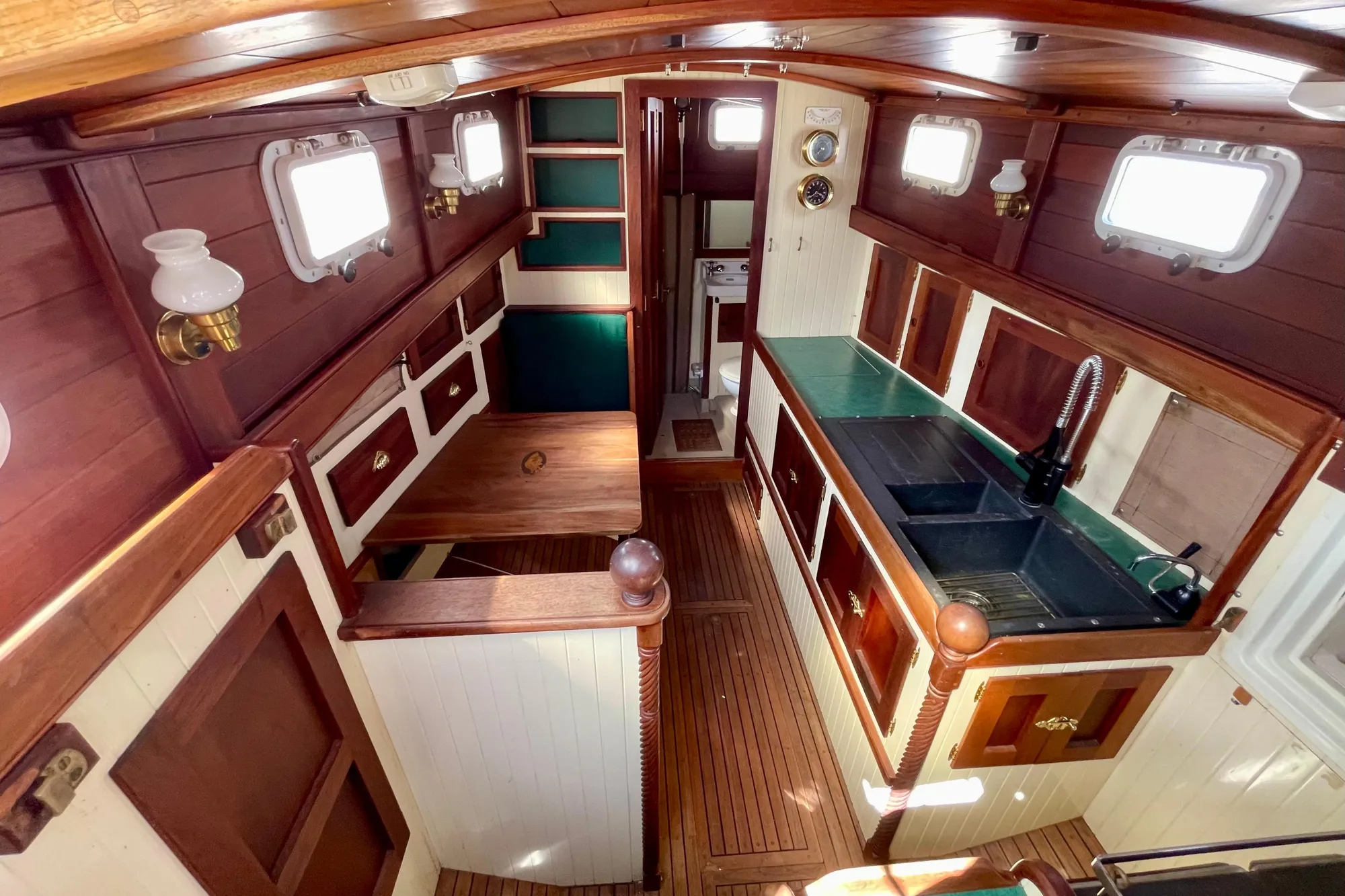 Interior of 2008 Pinky Custom boat with wooden cabinetry and compact kitchen area.