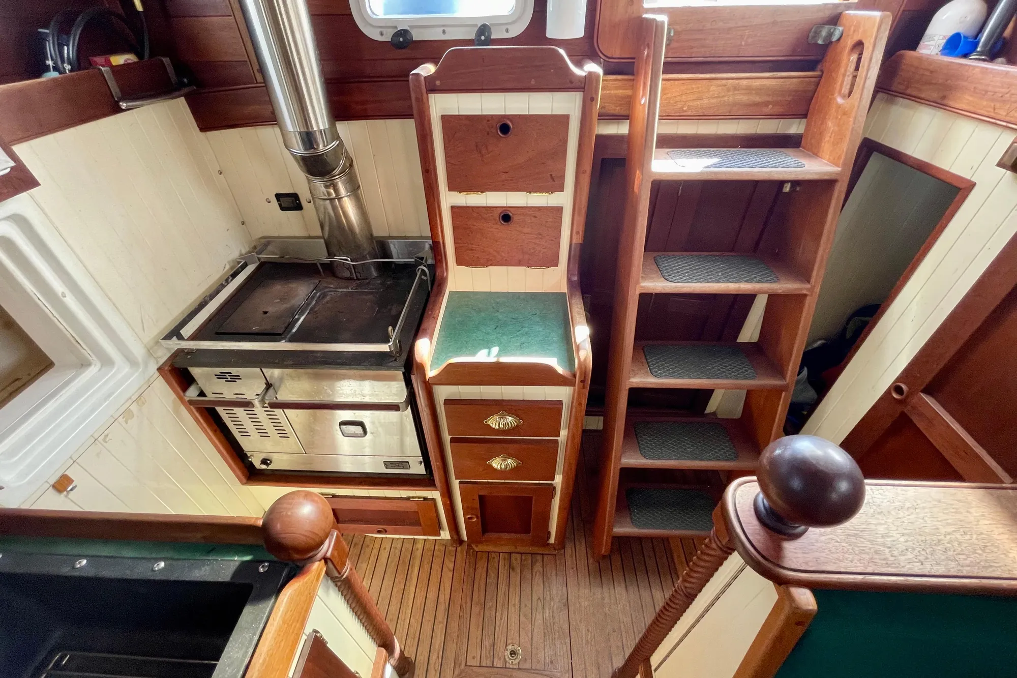 Wooden boat interior with stove, storage, and stairs, Pinky Custom 2008 model.