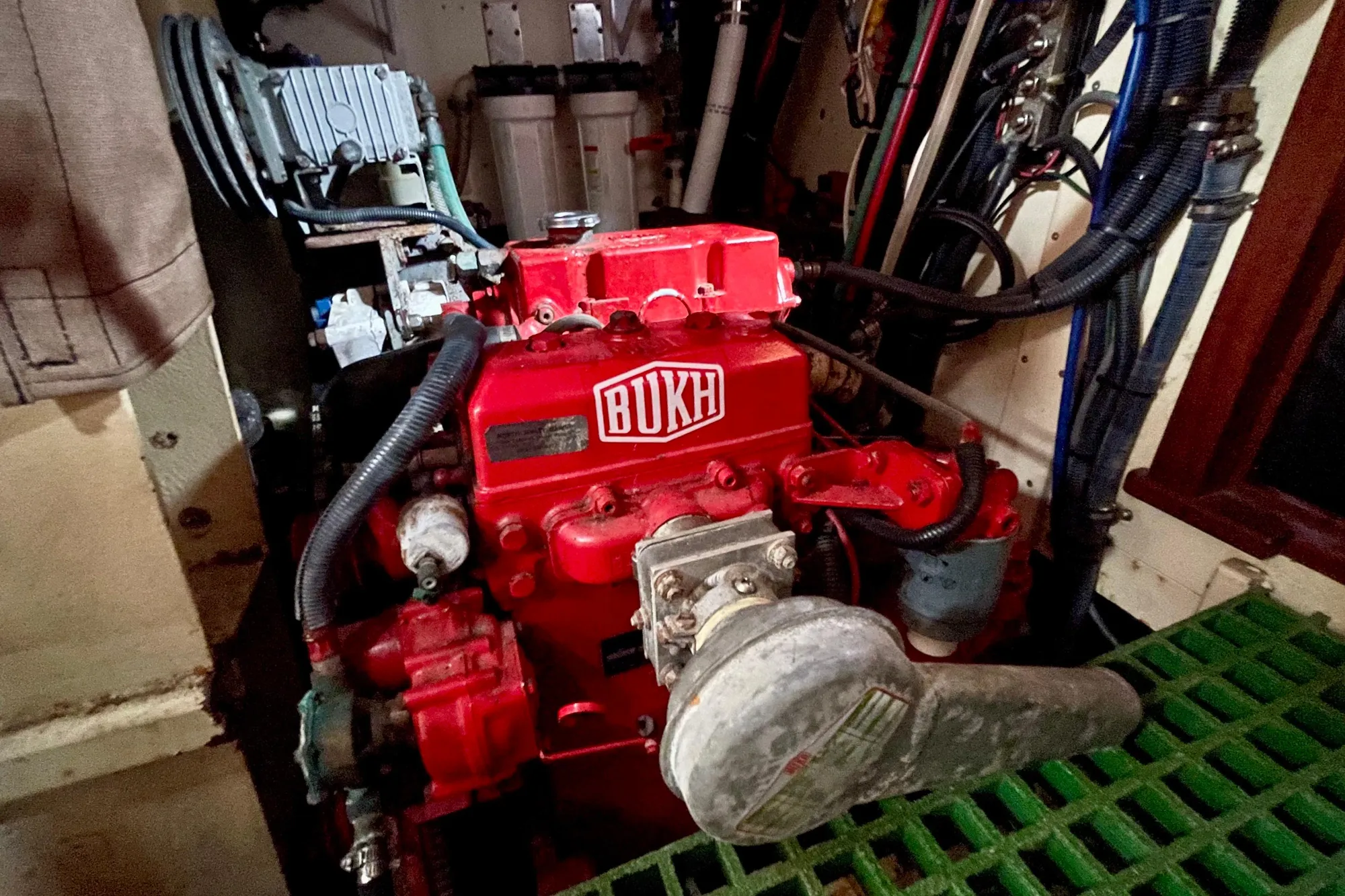 Red BUKH engine in a 2008 Pinky Custom boat, surrounded by cables and machinery.