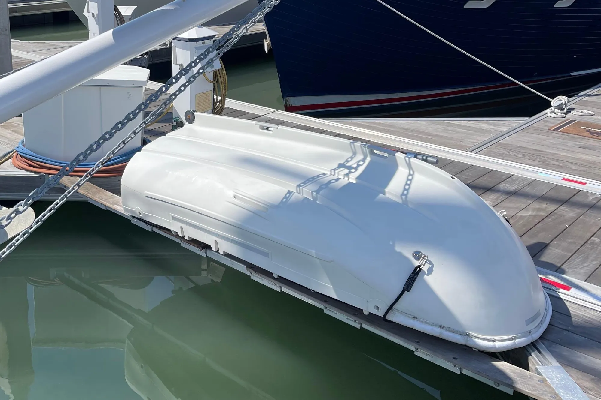 White Pinky Custom 2008 boat docked at marina, secured with chains.