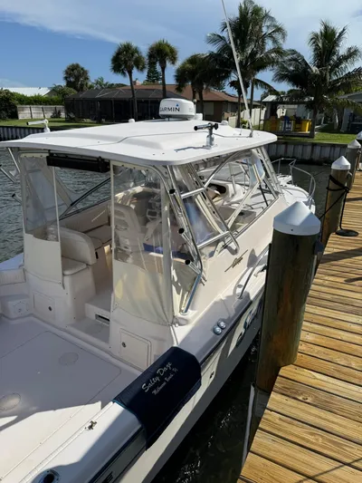  Yacht Photos Pics 2007 Grady-White Express 330 boat docked by a wooden pier, surrounded by palm trees.