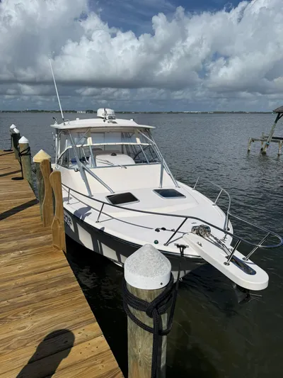 Yacht Photos Pics 2007 Grady-White Express 330 boat docked by wooden pier under cloudy sky.