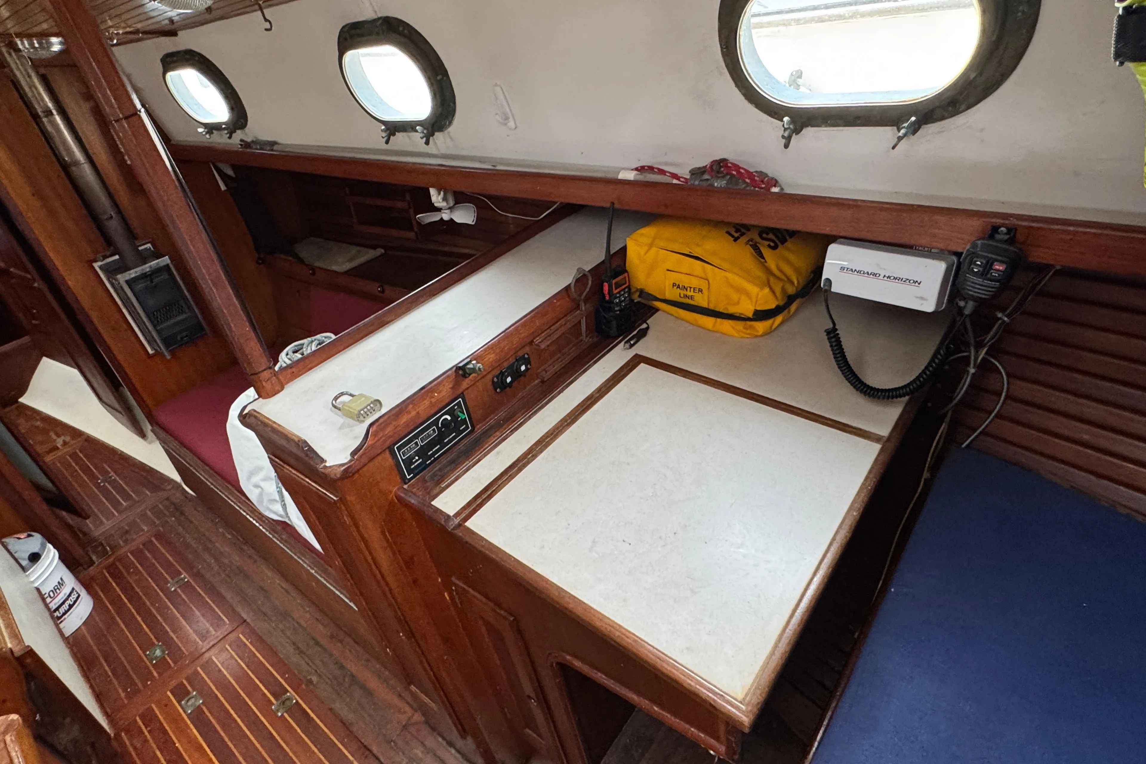 1977 Westsail Cutter interior with navigation station, wood paneling, and portholes.
