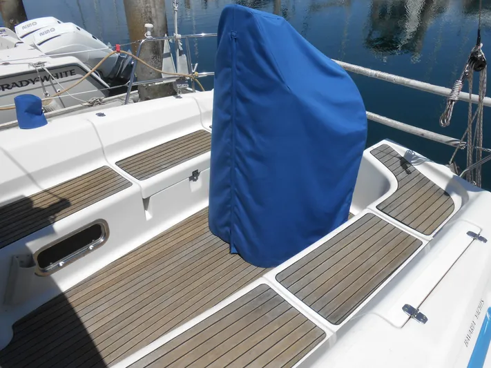 Pilitak Yacht Photos Pics Bavaria 37 sailboat deck, 2001 model, with blue cover and wooden flooring.