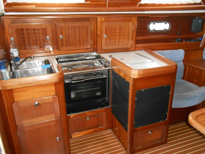 Pilitak Yacht Photos Pics Interior of 2001 Bavaria 37 yacht kitchen with wooden cabinetry and appliances.