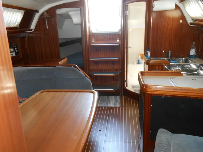 Pilitak Yacht Photos Pics Interior of 2001 Bavaria 37 yacht with wooden furnishings and compact kitchen area.