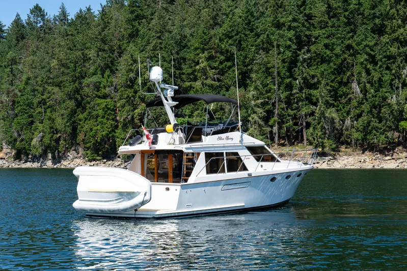 Silver Spring Yacht Photos Pics 1985 Ocean Alexander 420 Sport Sedan yacht on serene water, forested background.