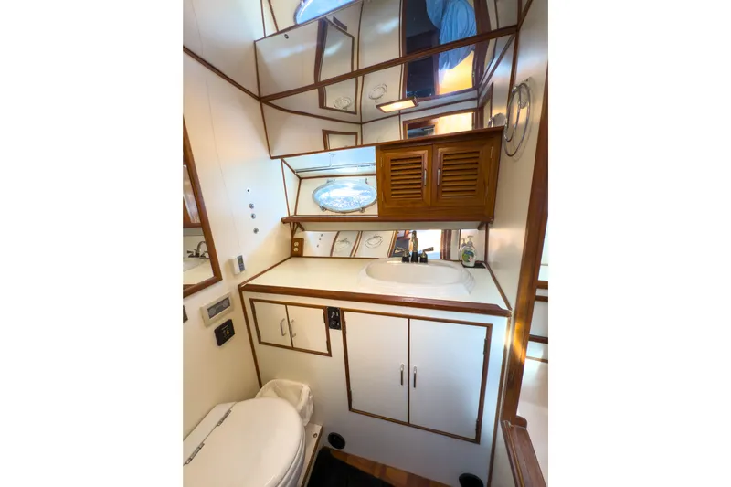 Silver Spring Yacht Photos Pics Bathroom interior of 1985 Ocean Alexander 420 Sport Sedan yacht, featuring wood accents and mirror.