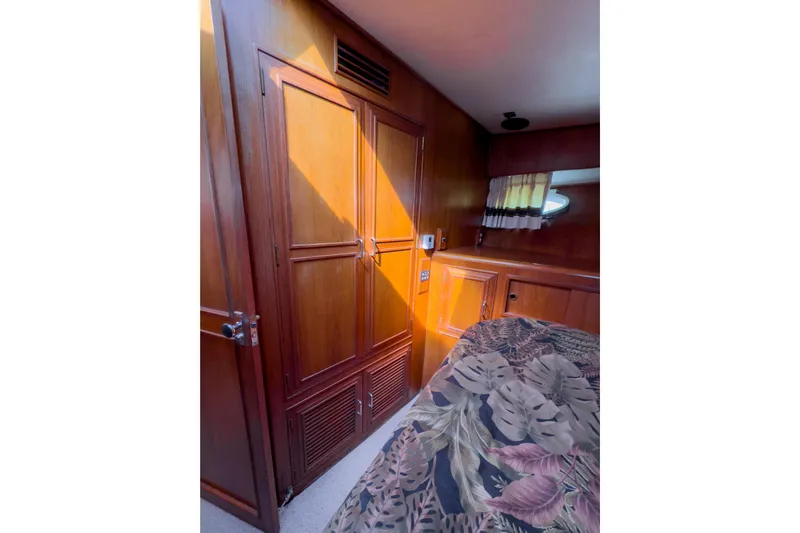 Silver Spring Yacht Photos Pics 1985 Ocean Alexander 420 Sport Sedan interior with wooden cabinetry and floral bedspread.