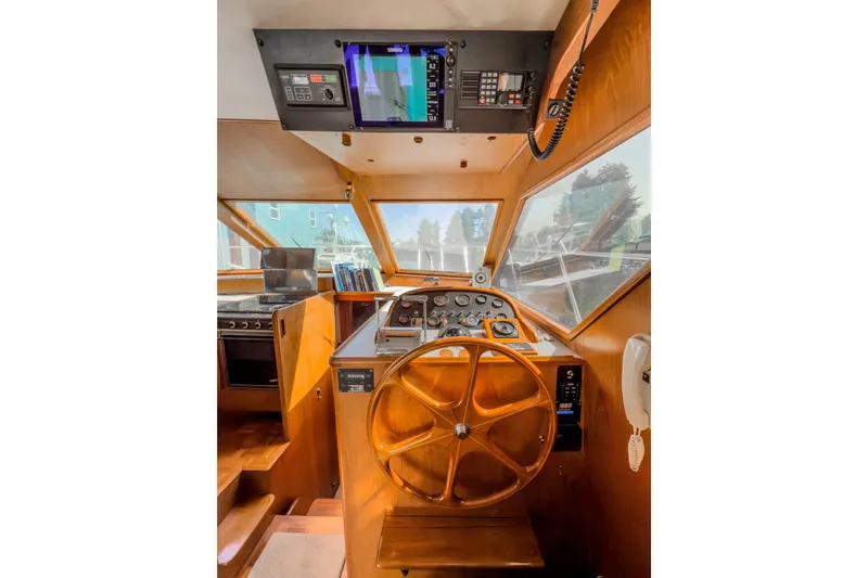 Silver Spring Yacht Photos Pics 1985 Ocean Alexander 420 Sport Sedan helm with wooden steering wheel and navigation equipment.