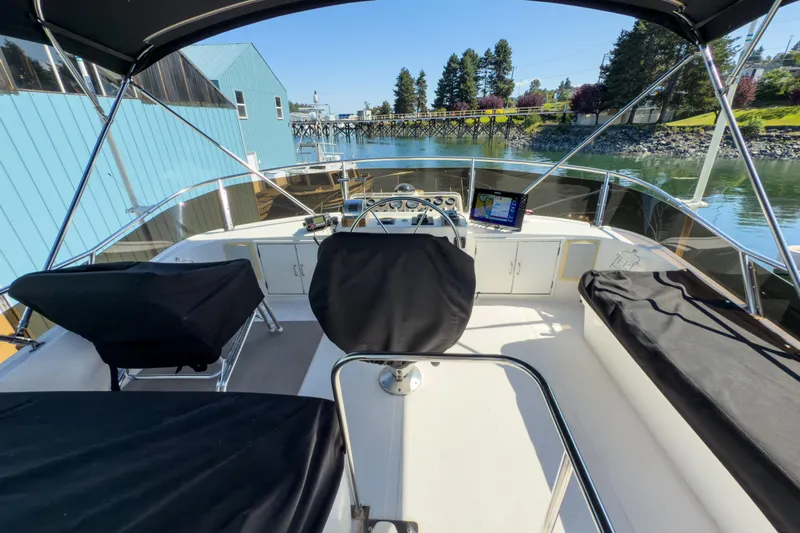Silver Spring Yacht Photos Pics 1985 Ocean Alexander 420 Sport Sedan cockpit with navigation equipment, docked by blue building.