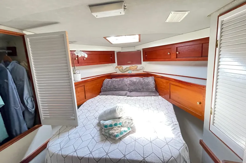 Aqua Ma'am Yacht Photos Pics Cozy bedroom in 1986 Ocean 38 Super Sport yacht with wooden cabinets and skylight.
