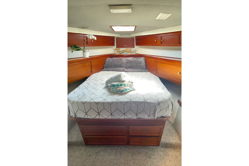 Aqua Ma'am Yacht Photos Pics 1986 Ocean 38 Super Sport cabin with cozy bed, wooden cabinets, and natural light.