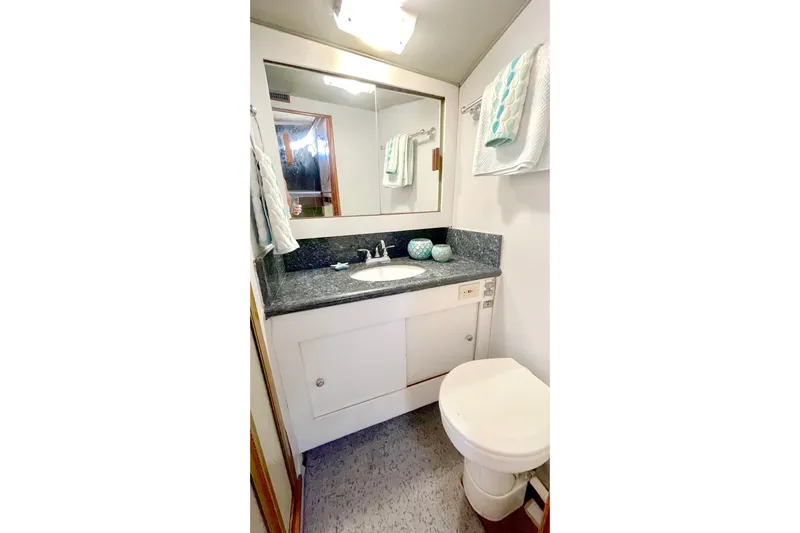 Aqua Ma'am Yacht Photos Pics Bathroom interior of 1986 Ocean 38 Super Sport yacht with sink, mirror, and toilet.