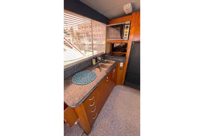 Aqua Ma'am Yacht Photos Pics 1986 Ocean 38 Super Sport yacht kitchen with wooden cabinets and granite countertops.