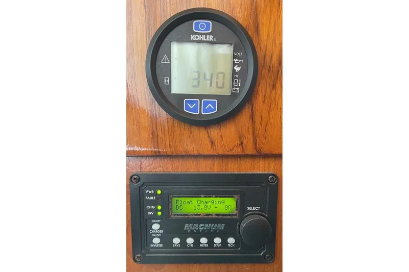 Aqua Ma'am Yacht Photos Pics Control panel on 1986 Ocean 38 Super Sport boat, displaying voltage and charging status.