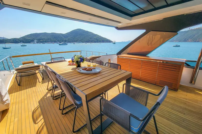  Yacht Photos Pics Luxurious 2017 Sanlorenzo SL78 yacht deck with dining area, overlooking serene waters and distant hills.