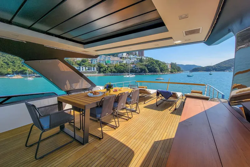  Yacht Photos Pics Luxurious 2017 Sanlorenzo SL78 yacht deck with dining area, overlooking serene coastal waters.