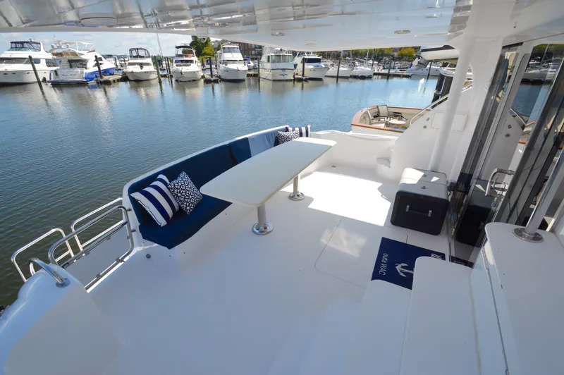  Yacht Photos Pics Spacious deck of 2006 Hatteras 64 Motoryacht with seating and table, overlooking marina.