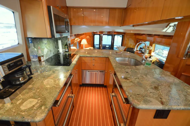  Yacht Photos Pics Luxurious kitchen interior of 2006 Hatteras 64 Motoryacht with granite countertops and modern appliances.