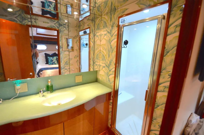  Yacht Photos Pics Luxurious bathroom in 2006 Hatteras 64 Motoryacht with tropical wallpaper and modern fixtures.