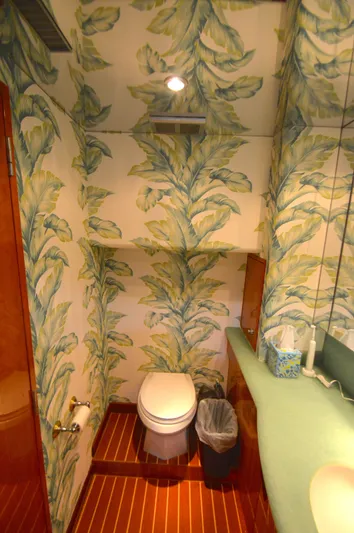  Yacht Photos Pics Bathroom with tropical wallpaper on a 2006 Hatteras 64 Motoryacht, featuring wooden flooring.