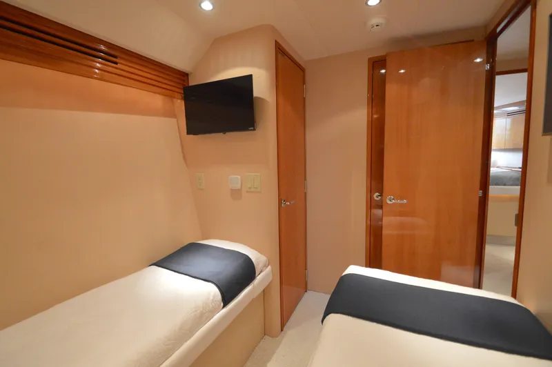  Yacht Photos Pics Interior of 2006 Hatteras 64 Motoryacht with twin beds and wall-mounted TV.