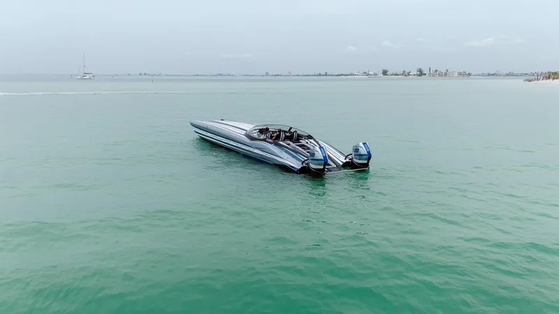  Yacht Photos Pics 2024 MTI 440X speedboat on calm turquoise water, showcasing sleek design and dual engines.