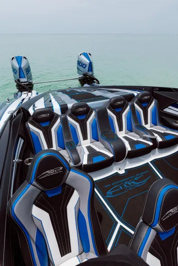  Yacht Photos Pics Luxury MTI 440X 2024 speedboat with sleek blue and black seating on calm water.