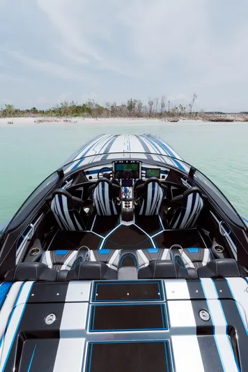  Yacht Photos Pics 2024 MTI 440X speedboat with sleek design, black and blue interior, on calm water.