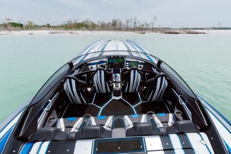  Yacht Photos Pics 2024 MTI 440X speedboat interior with sleek design, advanced controls, and striped seating on calm water.