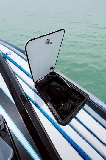  Yacht Photos Pics 2024 MTI 440X boat with open storage compartment on deck, near calm water.