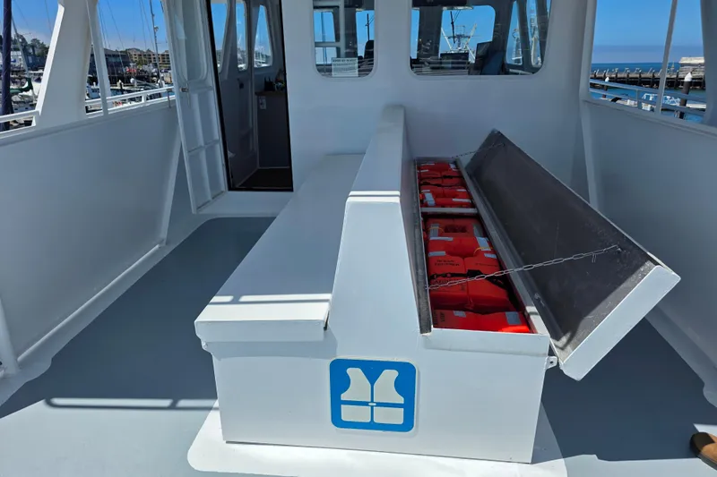 Ocean Thunder Yacht Photos Pics Interior of 1986 Gulf Craft Passenger boat with life jackets stored in a bench compartment.