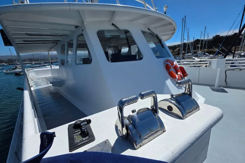 Ocean Thunder Yacht Photos Pics 1986 Gulf Craft Passenger boat with lifebuoys, docked in a marina under clear blue skies.