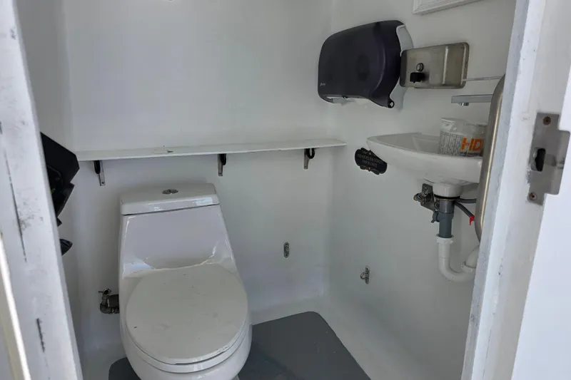 Ocean Thunder Yacht Photos Pics Compact bathroom on a 1986 Gulf Craft Passenger vessel, featuring a toilet and sink.