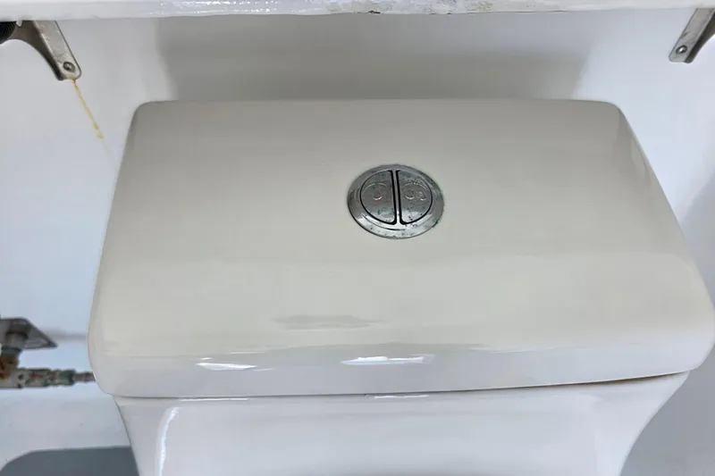 Ocean Thunder Yacht Photos Pics White toilet tank with dual flush buttons, close-up view.