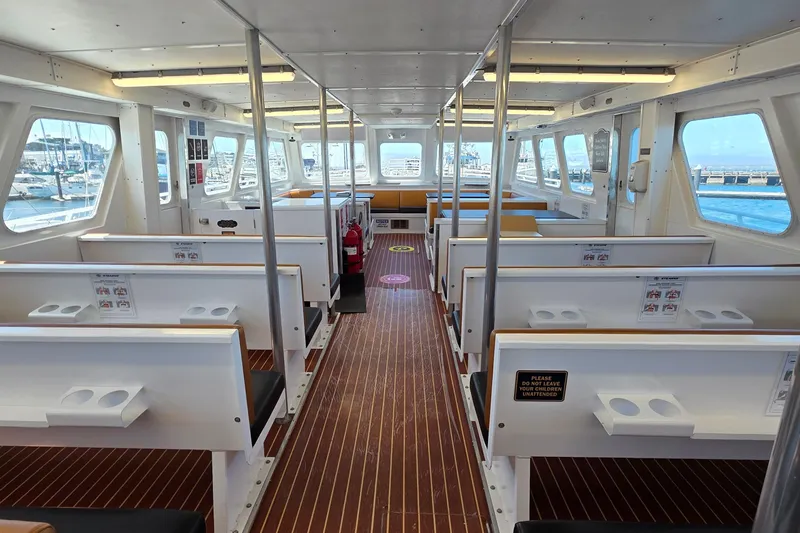 Ocean Thunder Yacht Photos Pics Interior of 1986 Gulf Craft Passenger boat with seating and windows overlooking marina.