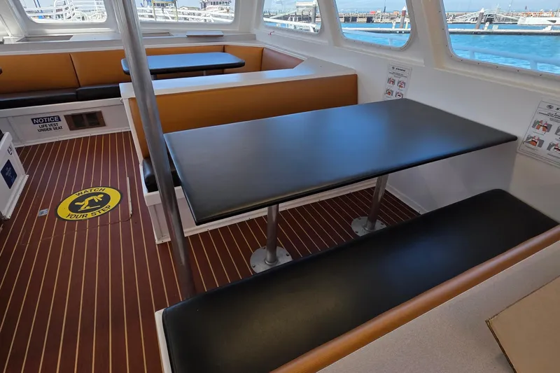 Ocean Thunder Yacht Photos Pics Interior of 1986 Gulf Craft Passenger boat with seating and safety signage.