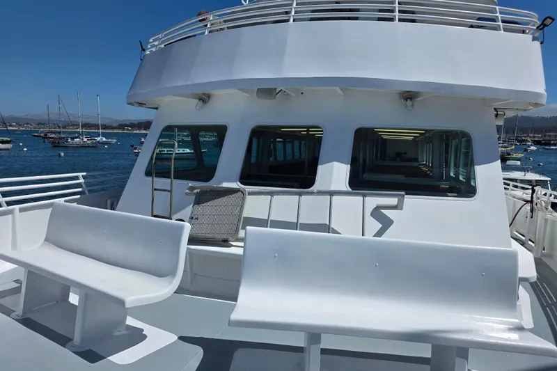 Ocean Thunder Yacht Photos Pics 1986 Gulf Craft Passenger boat with white benches, docked in a marina.
