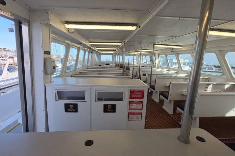 Ocean Thunder Yacht Photos Pics Interior of 1986 Gulf Craft Passenger boat with seating and trash bins.