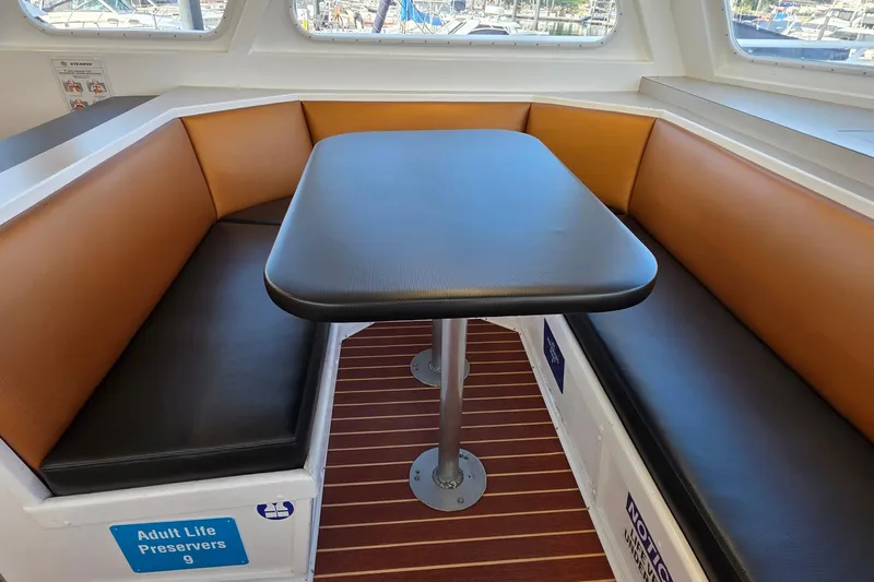 Ocean Thunder Yacht Photos Pics Interior of 1986 Gulf Craft Passenger boat with cushioned seating and table.