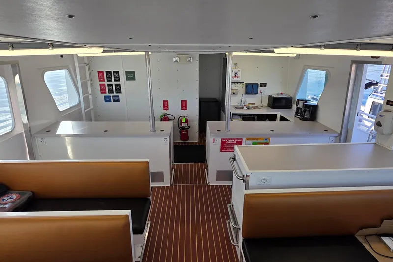 Ocean Thunder Yacht Photos Pics Interior of a 1986 Gulf Craft Passenger boat with seating and kitchen area.