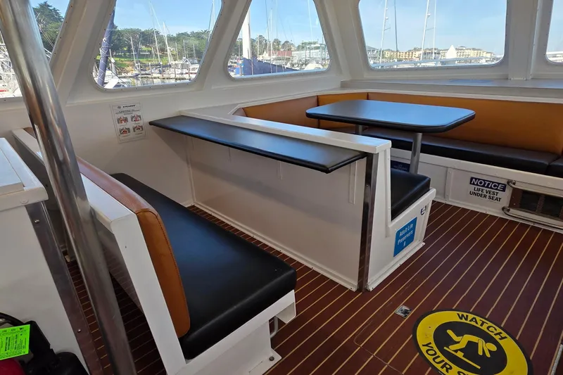 Ocean Thunder Yacht Photos Pics Interior of a 1986 Gulf Craft Passenger boat with seating and safety signage.